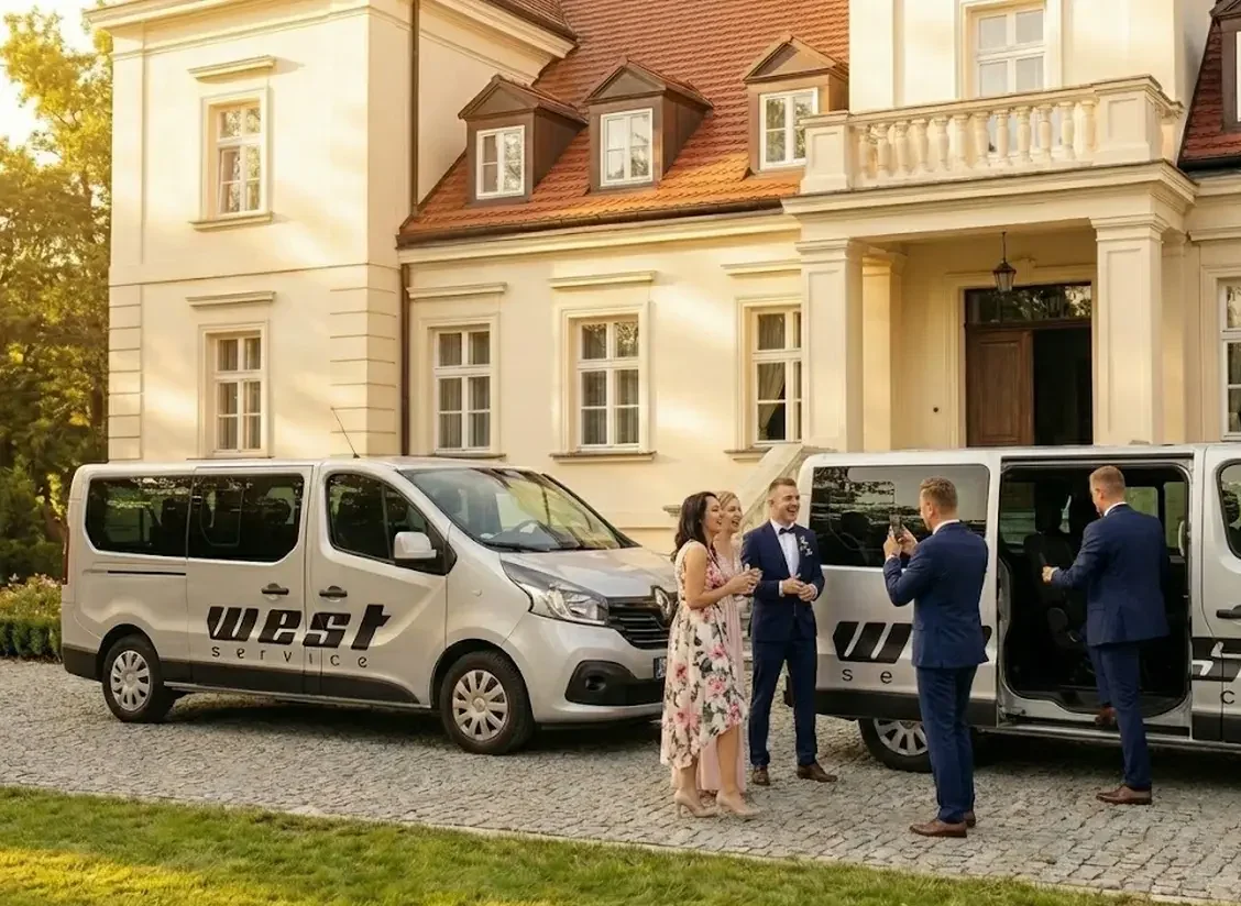 Goście weselni robią sobie zdjęcie z państwem młodymi. W tle widoczny jest dom weselny i busy West Service.
